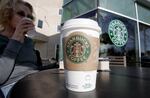 FILE - In this Feb. 26, 2008 file photo, a Starbucks customer drinks coffee in Palo Alto, Calif.