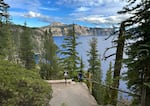 FILE - A child stands at the edge of the Cleetwood Cove trail in Crater Lake National Park on Aug. 15, 2025. The trail will be closed for rehabilitation from the summer of 2026 to the summer of 2029.