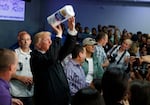 President Donald Trump tosses paper towels into a crowd. 