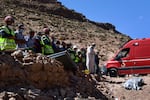 Rescue teams and civil protection members pray as a body is buried in Imi N'Tala, Morocco, on Sept. 13.