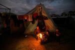 Displaced Palestinians keep warm by a fire near their tent on Jan. 23, 2024.