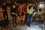 Emergency workers carry an injured person following Russian missile attacks in Kyiv, Ukraine, Monday, July 6, 2026.