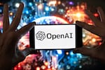FILE - The OpenAI logo is displayed on a cell phone in front of an image generated by ChatGPT's Dall-E text-to-image model, Dec. 8, 2023, in Boston.