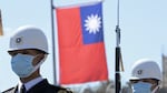 Taiwanese honor guards stand by under a national flag during a military ceremony in front of the presidential office in Taipei on March 9.