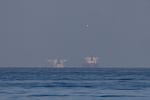 Commercial vessels are seen in the Gulf, near the Strait of Hormuz, in northern Ras al Khaimah, United Arab Emirates, on Sunday.