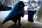 A person wearing a sleeping bag walks to Friendly House which opened as an emergency warming shelter on Saturday, Jan. 13, 2024, in Portland, Ore.