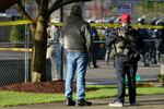 An armed supporter of President Donald Trump looks in at a gathering of Washington State Patrol troopers behind a perimeter fence during a rally, Sunday, Jan. 10, 2021, at the Capitol in Olympia, Wash. Protesters from several causes rallied Sunday at the Capitol, the day before the 2021 legislative session was scheduled to begin.