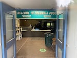 a front desk with a large sign above saying "Welcome to Columbia Pool"