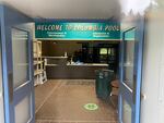 a front desk with a large sign above saying "Welcome to Columbia Pool"