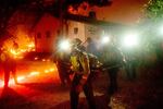A hand crew works to save a home as the Bear Fire burns through the Berry Creek area of Butte County, Calif., on Wednesday, Sept. 9, 2020. The blaze, part of the lightning-sparked North Complex, expanded at a critical rate of spread as winds buffeted the region.