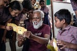 Pandiarajan excitedly shows his students a view of the specimen in a foldscope, using his smart phone.