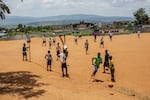 Students play near a genocide memorial site in Gahanga.