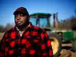 Lucious Abrams, a plaintiff in the Pigford v. Glickman class action lawsuit, stands in front of a tractor on his Georgia farm.