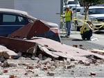 City workers at right map out the installation of fencing around earthquake damaged buildings Tuesday, Aug. 26, 2014, in Napa, Calif.