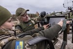 Two women put together a Maxim machine gun during training.