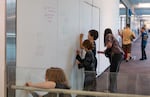 Jeanine Comstock, left, Soren Vinet, 11, center left, Oskar Brooks, 9, center right and Jennifer Lin, right, draw on the walls at the Lloyd Center on its last day before closing in Portland, Ore., on Aug. 8, 2026. Attendees of the final day write notes and draw art with a variety of art supplies on the walls inside the Lloyd Center.