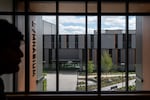 A student, left, walks by a window opening up to the new courtyard.