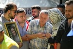 Mehmet Suat Eygi (C), father of late US-Turkish activist Aysenur Ezgi Eygi shot dead by Israeli forces while protesting against Israeli settlements in the West Bank, mourns in front of a portrait of his daughter during her funeral ceremony at the cemetery in Didim, Aydin Province, on Sept. 14, 2024.