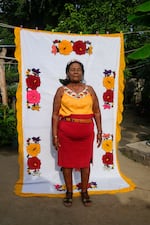 Tomasa Noyola, a leader in San Nicolás, in her garden on a background of one of the many textile handmade pieces crocheted by her.