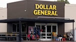 The exterior of a Dollar General store shows the budget retailer's signature brown siding and large yellow letters.
