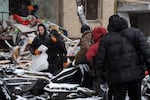 Residents take their belonging amid debris of their home heavily damaged in Tuesday's Russian missile attack in Kyiv, Ukraine, Wednesday, Jan. 3, 2024. (AP Photo/Efrem Lukatsky)