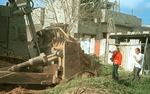 American activist Rachel Corrie (left), 23, stands between an Israeli bulldozer and a Palestinian house on March 16, 2003, in Rafah in the Gaza Strip. Corrie was run over and killed by an Israeli bulldozer as she protested the demolition of Palestinian houses.