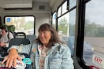 Woman smiling in a bus with a jean jack