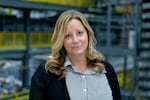 This photo shows Teri Ivaniszyn, DigiKey’s vice president of operational excellence and trade compliance. Photographed from about the waist up, she's wearing a buttoned shirt with alternating white and dark vertical stripes, as well as a dark cardigan over it.