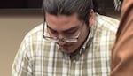 A photo of Julio Segura with his head down. He wears glasses and a plaid shirt inside a courtroom. A Clark County jury found 22-year-old Julio Segura guilty of murder on May 24, 2024. Segura engaged in a high speed chase in 2021 that led to a Clark County Sheriff's Office deputy shooting and killing an off-duty Vancouver police officer.