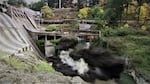 explosion at bottom of concrete dam.