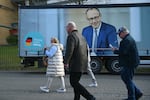 People walk past a truck with an election campaign poster featuring Friedrich Merz, leader of conservative Christian Democratic Union (CDU), in Oberhausen, Germany, on Feb. 21.