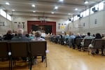 The parishioners of St. Joseph Catholic Church in Salem, Ore. gather for mass on May 18, 2025. They have been worshipping in the school auditorium for nearly two years, following a fire at the main church building.