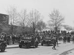 National Guard personnel and jeeps at Kent State University, with a crowd in the background.
