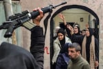 A man holds up an assault rifle as relatives mourn during the funeral of the two Ghazawi brothers, who were among three Palestinian men who were killed when undercover Israeli agents raided the Ibn Sina Hospital in the city of Jenin, in the occupied West Bank, on Jan. 30.