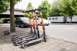 Commuters pass by a row of parked SPIN electric scooters on SW Naito Parkway in downtown Portland, Ore., on Friday, May 17, 2019.