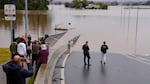 People look Tuesday at the flooded Windsor Bridge at Windsor on the outskirts of Sydney, Australia.