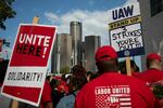 With the General Motors world headquarters in the background, United Auto Workers members attend a solidarity rally as the UAW strikes the Big Three automakers on Sept. 15 in Detroit. President Biden will join the workers in solidarity on Tuesday.