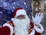 Rev. Dr. Leroy Barber, aka Black Santa, uses a giant snow globe to keep everyone safe at his events during the pandemic.