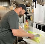 Hope Kitchen Kitchen Manager Robert Nash shows off his knife skills with a head of cabbage.