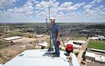 Wind turbine technician Terrill Stowe stands on the nacelle, which houses the gear box and generator of a wind turbine, on the campus of Mesalands Community College in Tucumcari, New Mexico, on July 11, 2024.