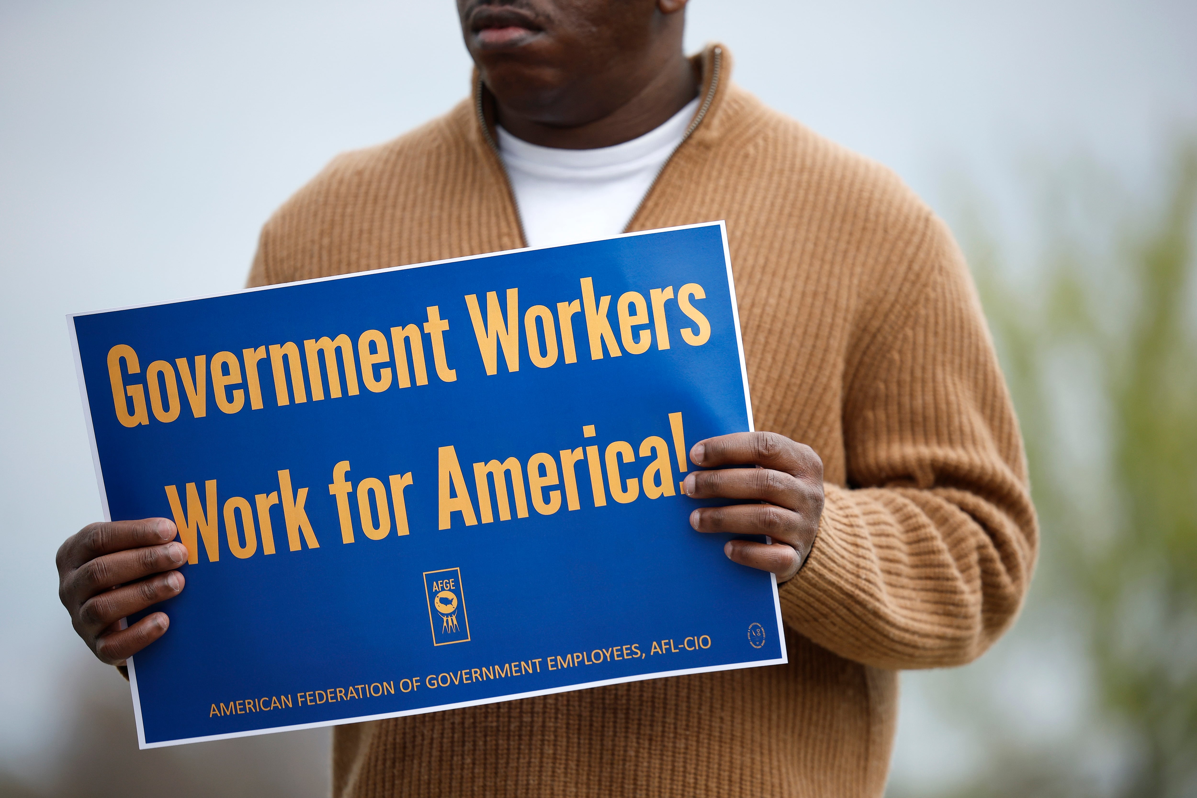 A union supporter holds a sign at a press conference on federal workforce rights outside the U.S. Capitol on March 28, 2025 in Washington, D.C.