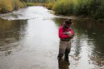 Fish technician Mystina Spinl-McCormack plugs in GPS coordinates to mark the location of a salmon redd on the Warm Springs River.
 