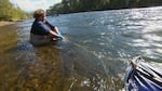 OPB's Jes Burns holds onto the sampling net in the Rogue River at Grants Pass.