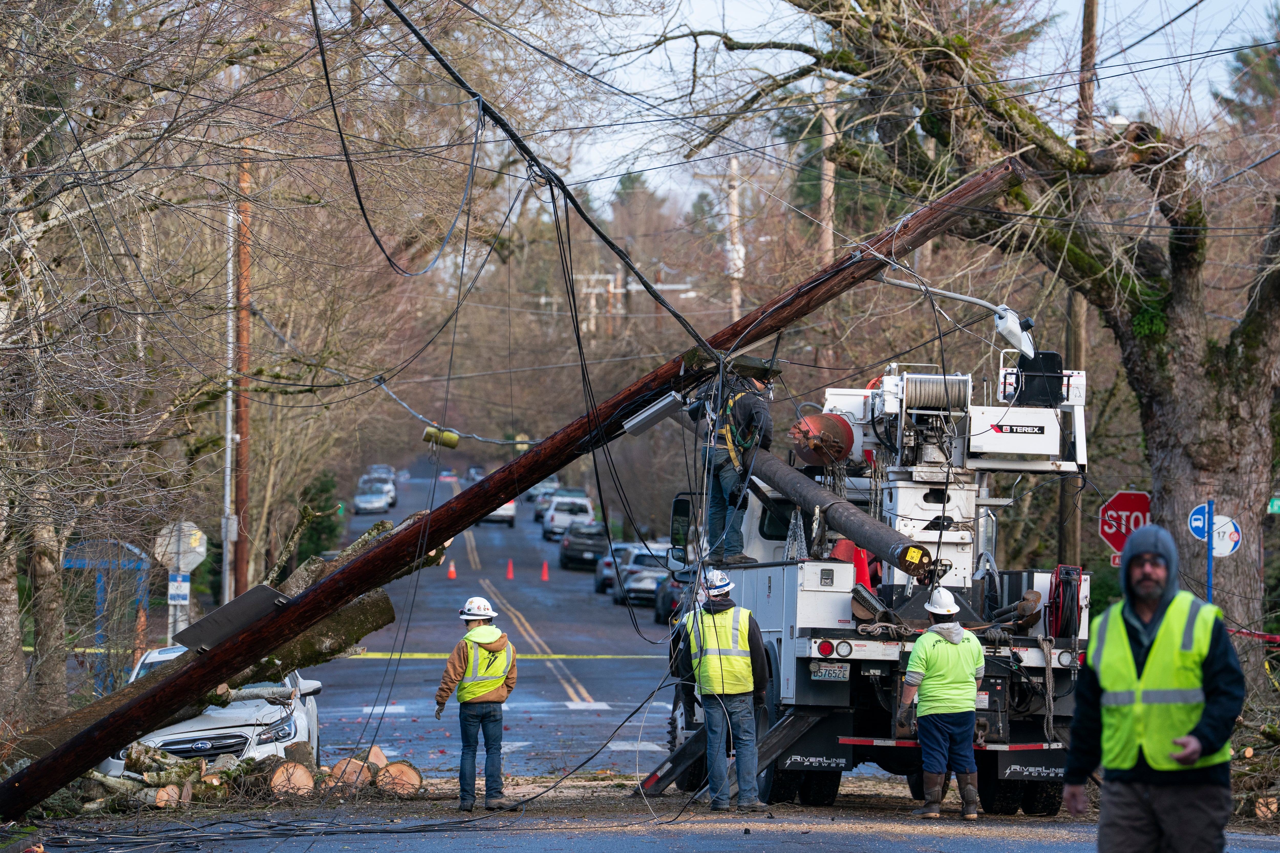 Workers remove a damaged electrical pole on Northeast 24th Avenue on Wednesday, Dec. 17., 2025 in Portland.