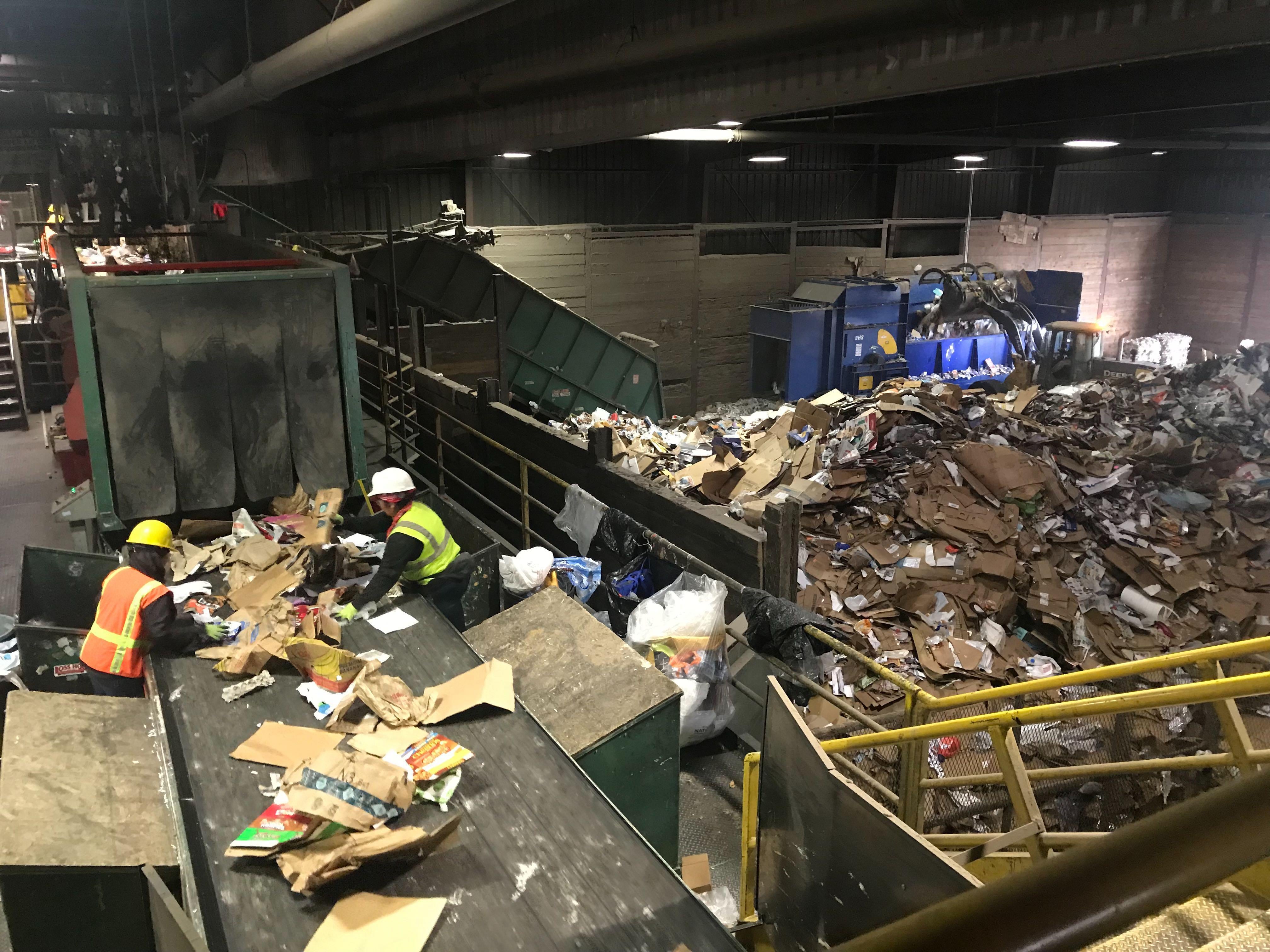 FILE - Hillsboro Far West Recycling workers look for plastic bags and plastics wraps in recycled materials to avoid jamming the sorting machine and delaying work.