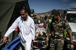 Military personnel transport on a gurney a survivor of the September 8 earthquake at a military field hospital in the village of Asni near Moulay Brahim in al-Haouz province in the High Atlas mountains of central Morocco on September 11, 2023.