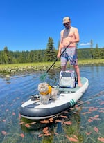 Justin Novicky standup paddle boarding on Hosmer Lake in Central Oregon with his cat, Blaze, in July of 2024.