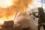 A rescue worker puts out a fire at residential houses destroyed in a Russian strike on Kharkiv, Ukraine, Sunday, Oct. 11, 2026.