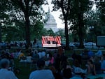 People gather in a park outside of the U.S. Capitol to watch the Jan. 6 House committee investigation hearing on Thursday night. The panel convened again the morning of Monday, June 13, 2022.