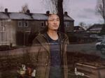 With his family stuck in Thailand, Chinese dissident Gao Zhi looks out the window of his home in a small village in the Netherlands.